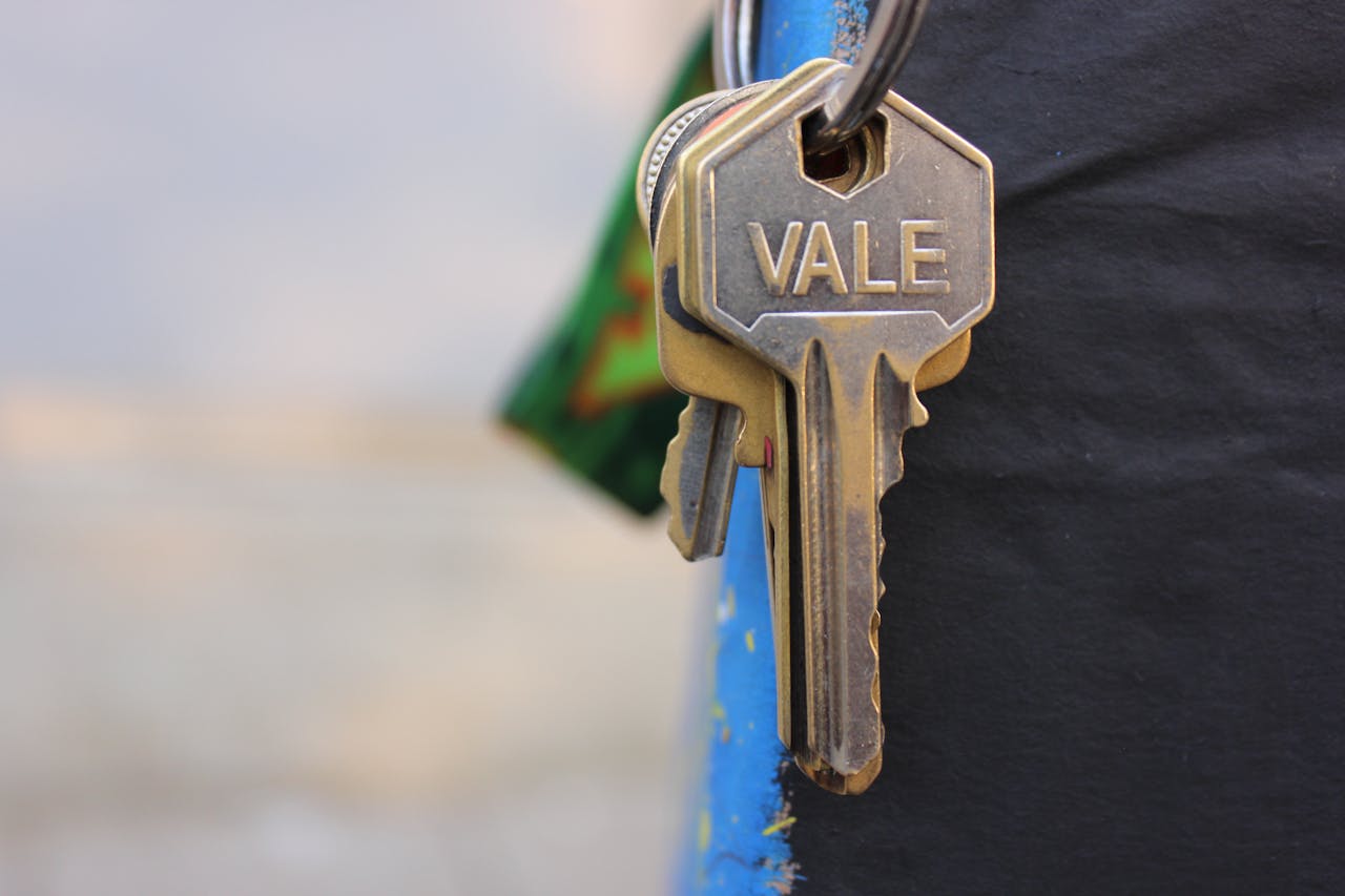A detailed view of a metallic key with Vale engraved on it, hanging against a blurred background.